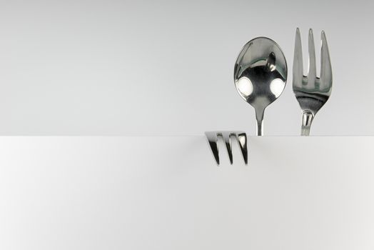 Metal spoon and two forks formed into conceptual fantasy figure
