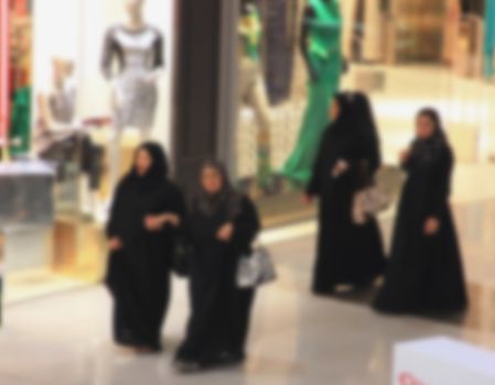 Arab women make purchases walking, Islam, Shopping center and retail shops, shop in Dubai, blurred background