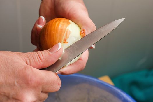 closeup hands clean onions, cleaning raw fresh onion, cooking in the kitchen