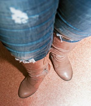 female legs in brown boots, women's shoes, heels, out of focus