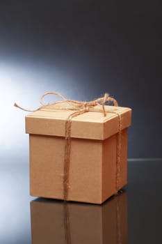 Cardboard box tied with twine on dark background