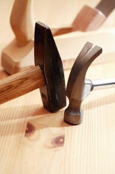 Two hammers near plane on wooden workbench