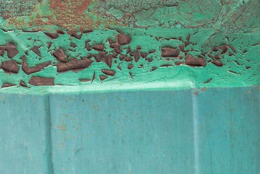 fragment of a rusty iron surface covered with old paint, which has long been under the influence of different climatic conditions