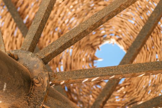 Wicker metal vintage umbrella on a background of blue sky, fragment.