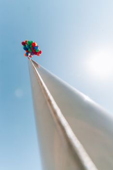 many bright baloons in the blue  sky on the pillar