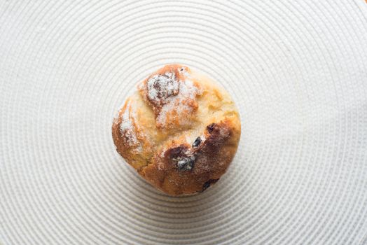 Homemade carrot muffin with empty space on white fabric background. Copyspace top view.
