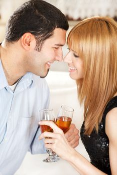 Happy young couple toasting their anniversary with champagne at home ambient