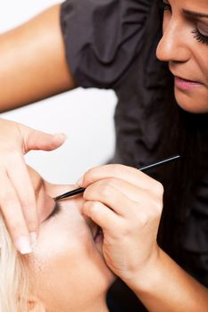 Make-up artist applying makeup on beautiful woman
