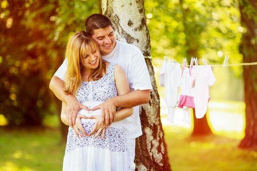 Happy Pregnant couple making Heart Shape 