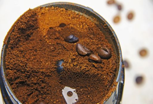 coffee is ground in a coffee grinder Natural ground coffee heap and coffee beans soft focus