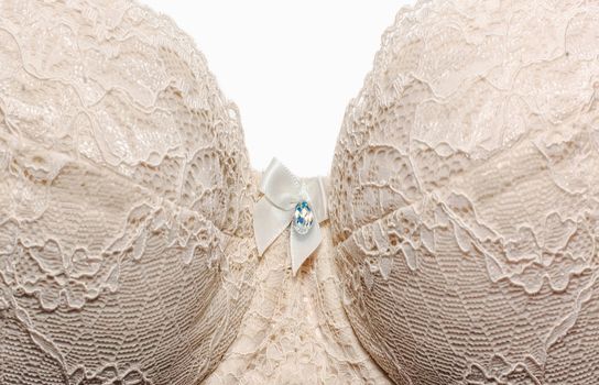 lace bra light color on a white background, isolated, fashionable lingerie for the bride, soft focus