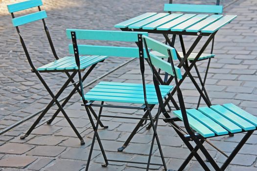 cafe chairs and tables on the street, blue, soft focus