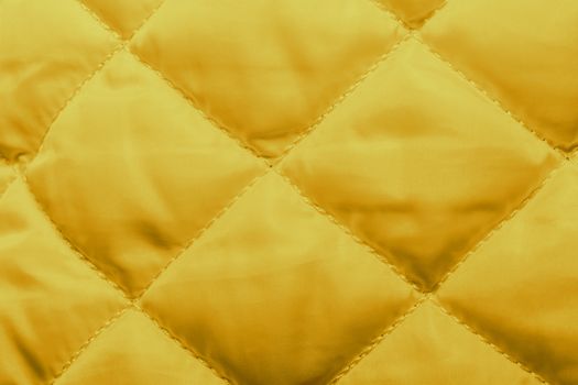 quilted fabric texture of yellow color for hammering, backgrounds and textures