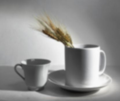 White jug vase with spikelets of wheat for a cup still life blurred background