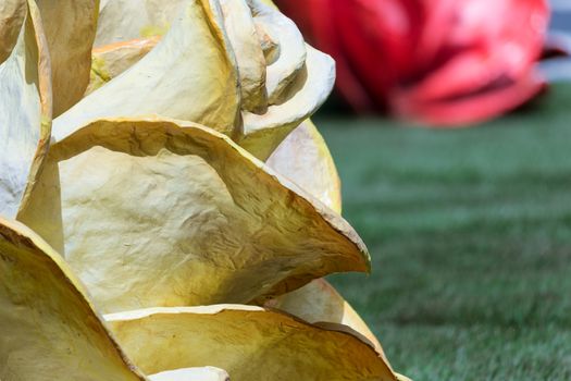 A rose of papier-mâché on a green grass