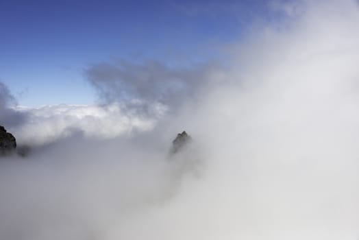 the high mountains at madeira island called pico arieiro coming out of the clouds, the top is 1818 meters above sea level