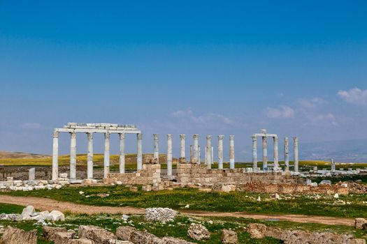 View of historical ancient city of Laodicea in Denizli with high columns on bright blue sky background.