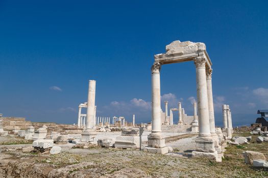 View of historical ancient city of Laodicea in Denizli with high columns on bright blue sky background.