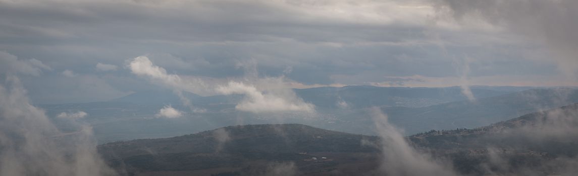 View of the Hermon mountains covered in mist .