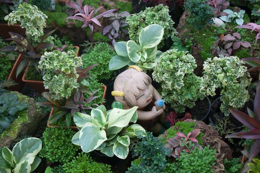 Landscaping with trees and green clay figurines with girls.