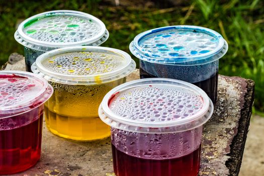 containers with food coloring on an old stool