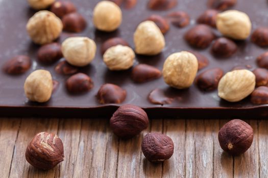 milk chocolate with hazelnuts on a wooden background