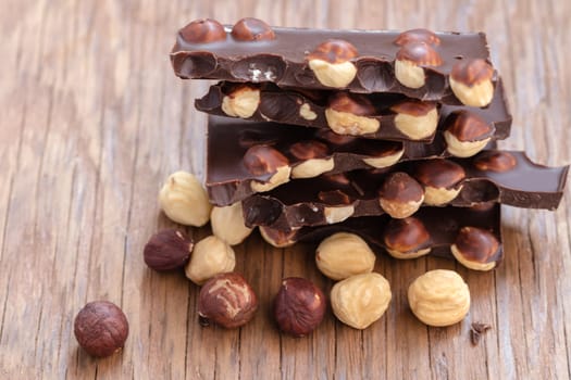 milk chocolate with hazelnuts on a wooden background