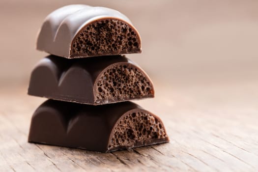 part porous chocolate close-up on a wooden background