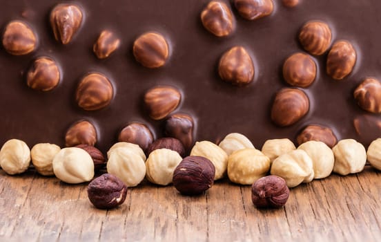 milk chocolate with hazelnuts on a wooden background
