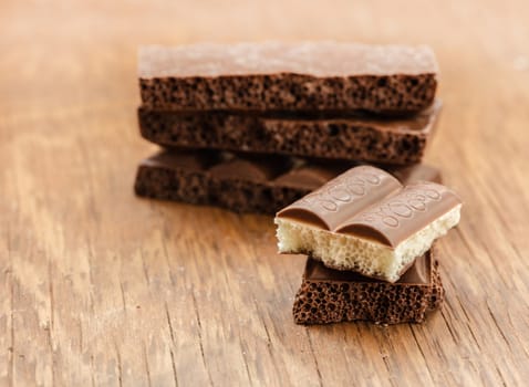 part porous chocolate close-up on a wooden background