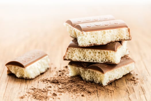 part porous chocolate close-up on a wooden background