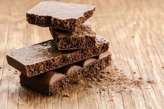 part porous chocolate close-up on a wooden background