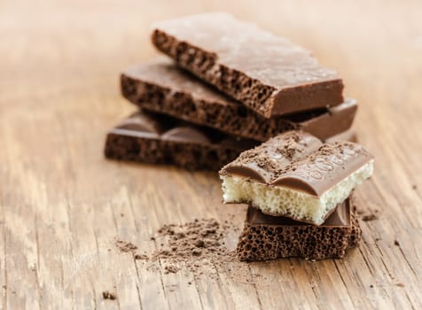 part porous chocolate close-up on a wooden background