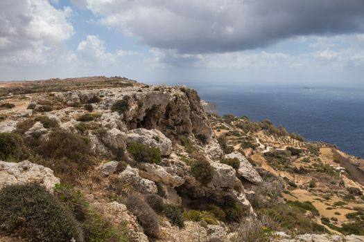 Dingli Cliffs, one of the most beautiful parts of the shore at the island Malta. Water of the Mediterranean sea. Cloudy sky