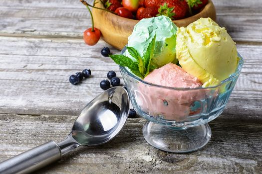 Bowl with fruit ice cream scattered on background of blueberries