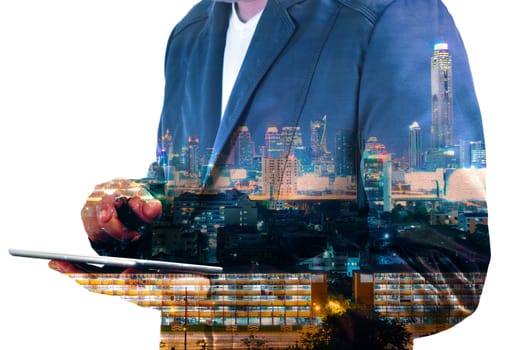 Double Exposure image of Businessman use Digital Tablet and City Building at Twilight