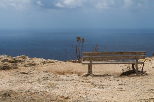 At the top of the Dingli Cliffs, wooden bench with a panoramic sea view. Mediterranean island Malta.
