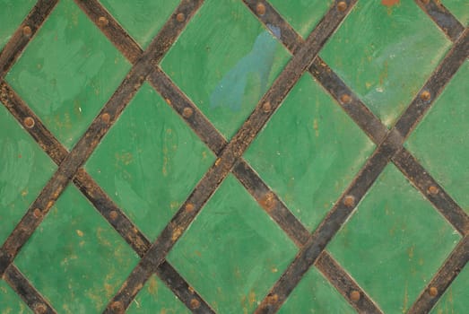 fragment of an iron surface is covered with green color paint, which has long been under the influence of different climatic conditions