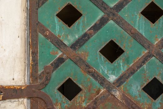 fragment of an iron surface is covered with green color paint, which has long been under the influence of different climatic conditions