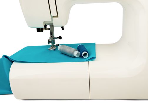 Machine sews with blue textile fabric on white background
