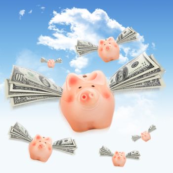 Pink piggy banks flying free with dollar wings in sky