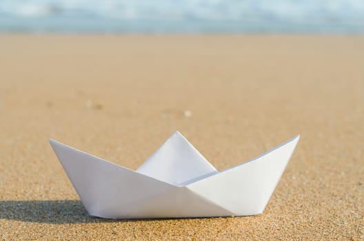 white paper boat on beach, summer holiday