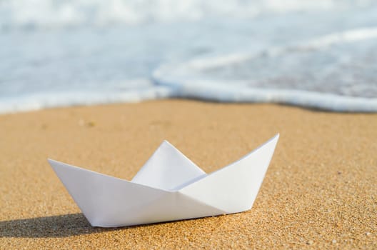 white paper boat on beach, summer holiday