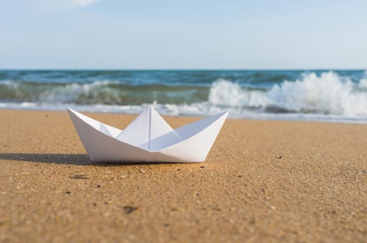 white paper boat on beach, summer holiday