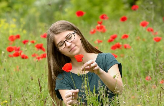Portrait of young girl in a poppy field