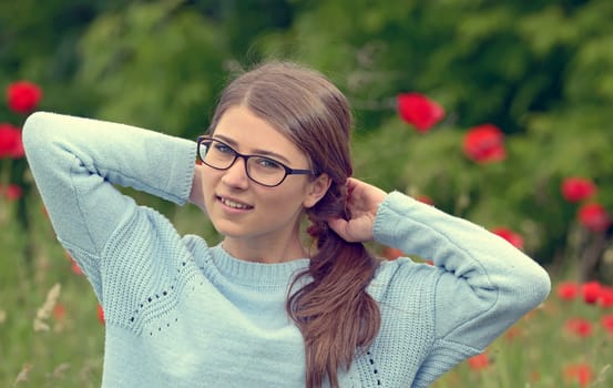 Portrait of young girl  in a poppy field