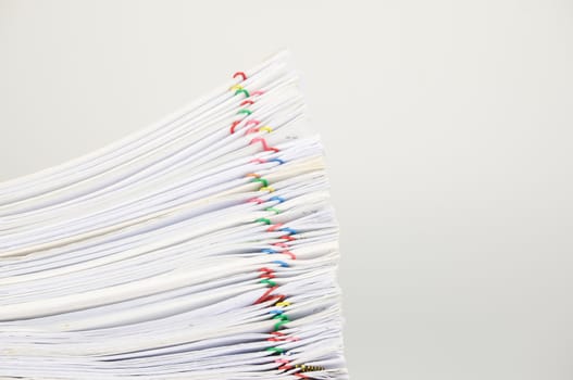 Overload paperwork of report and receipt with colorful paperclip on white background.