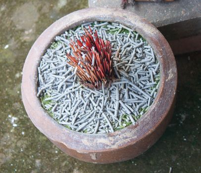 Incense sticks in ashes bucket
