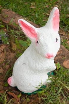 Statue of rabbit in the garden, mouth and ears are pink.