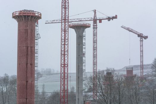 Bridge construction sites, bridge under construction seen in heavy snowfall from below.